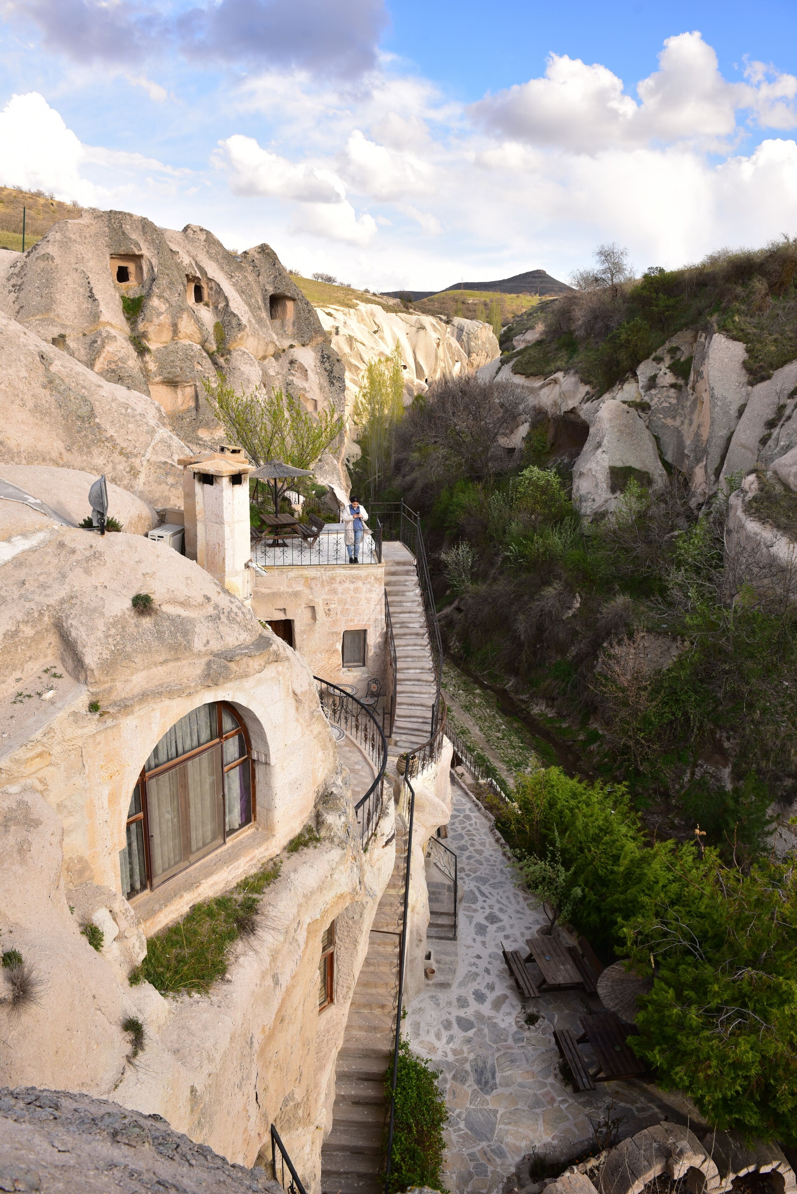 A stone building with multiple windows and a staircase leading to a terrace.