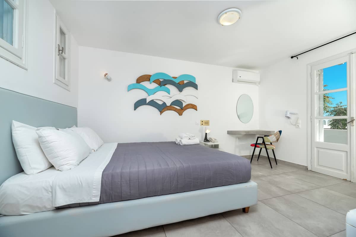 A bedroom with a bed, a desk, and a chair.