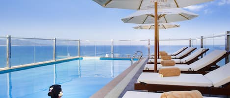 Outdoor pool, a rooftop pool, pool umbrellas, pool loungers