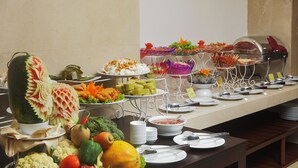 A buffet table with various food items and a decorative centerpiece. - Regalia Hotel (Nha Trang)