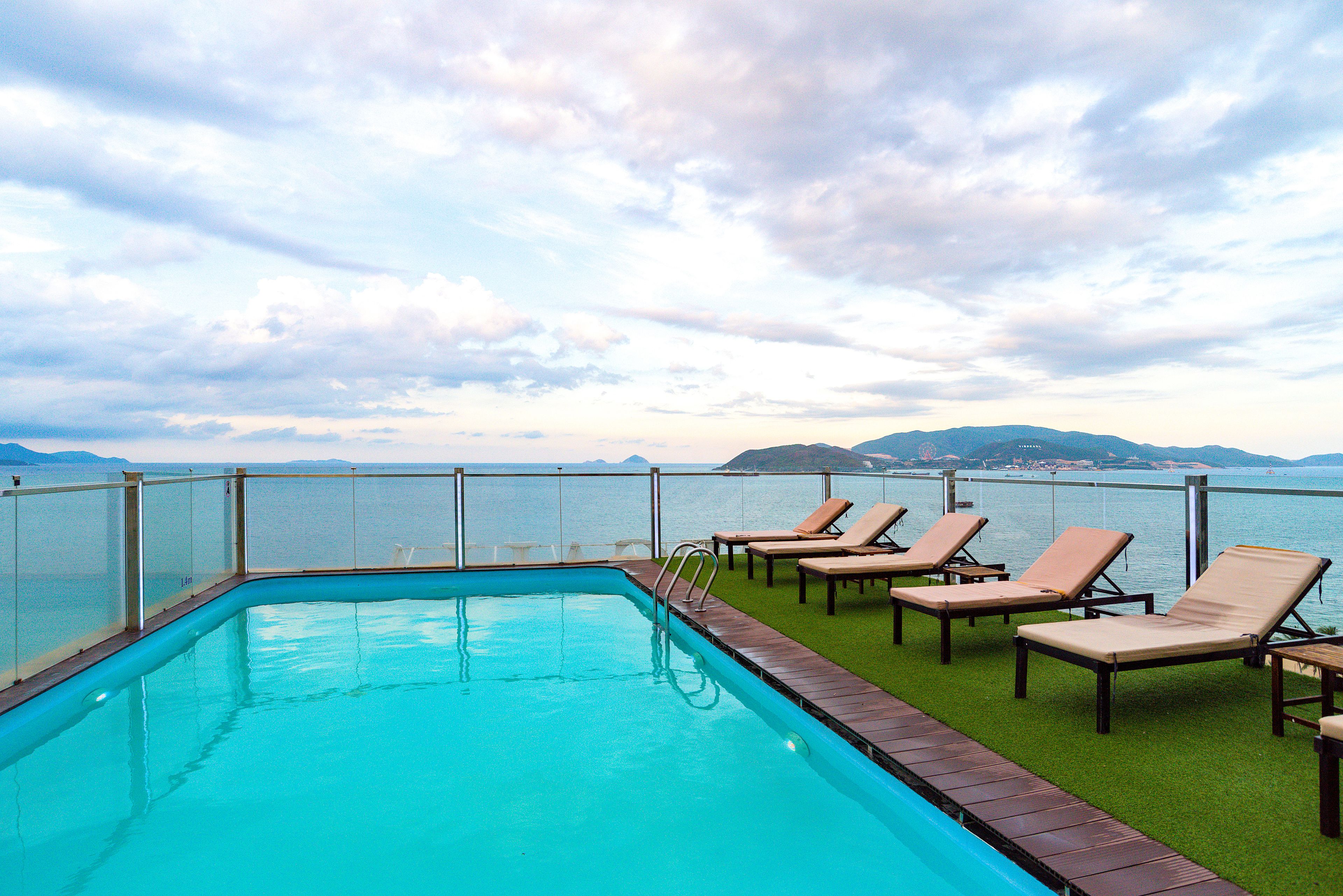 outdoor pool, a rooftop pool, pool umbrellas, pool loungers