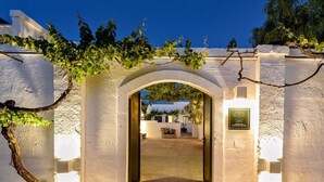 An arched entrance to a building with a sign indicating a vineyard. - Masseria Narducci (Fasano)