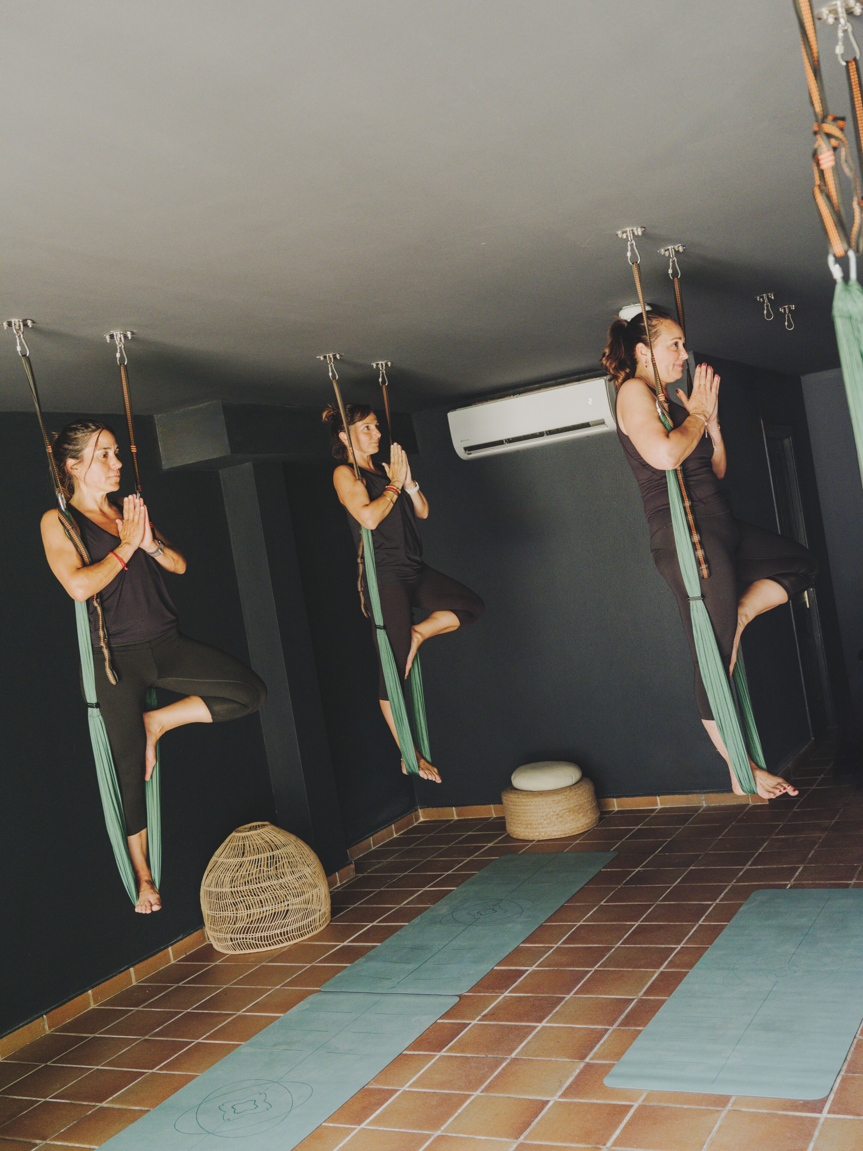 Une pièce équipée d’un tapis de yoga, d’un panier en osier et d’un climatiseur fixé au mur.
