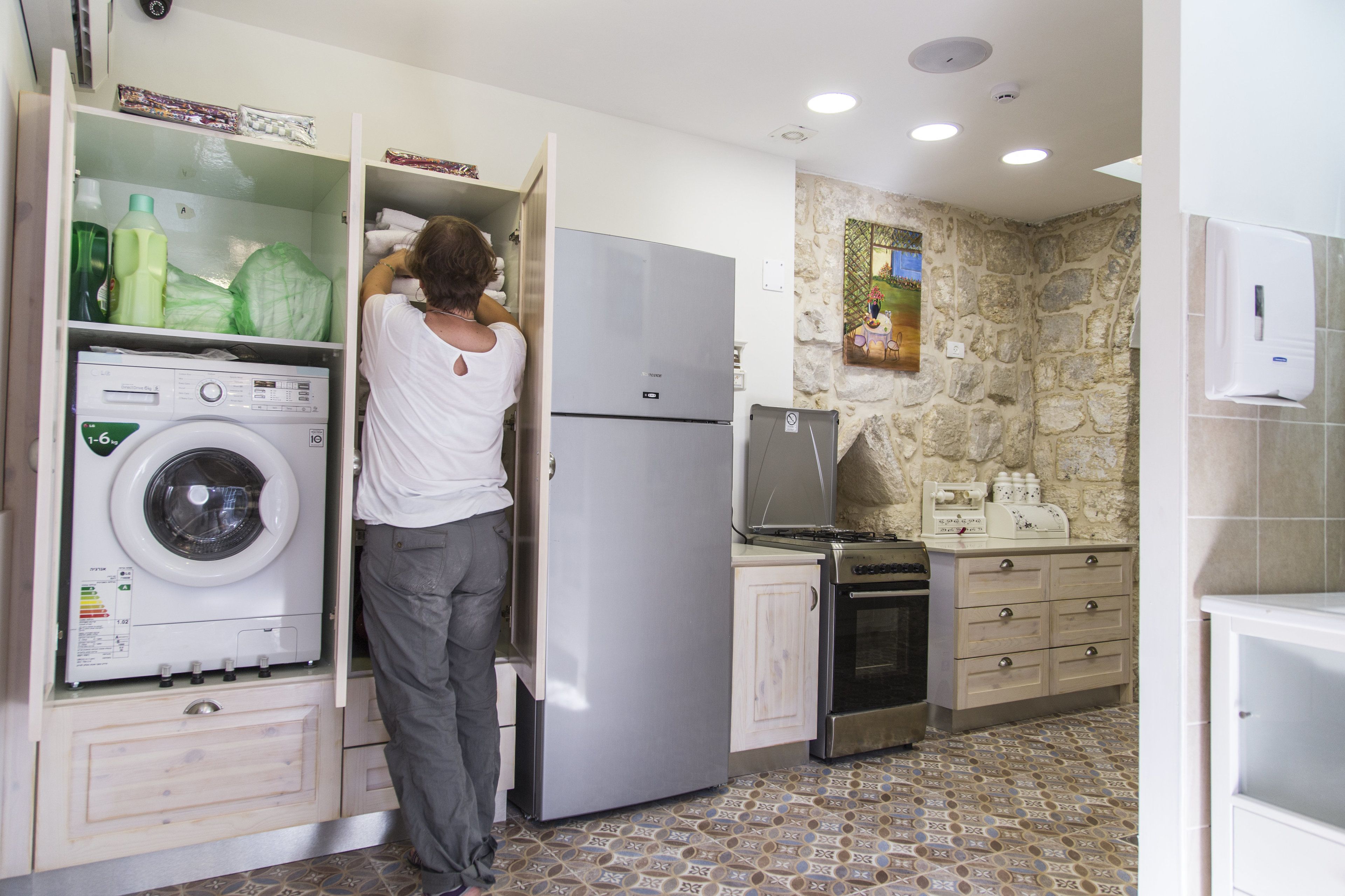A compact kitchen with a washing machine, a refrigerator, a stove, and a sink.