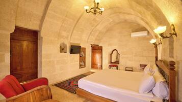 A bedroom with a large bed, wooden furniture, and a chandelier.