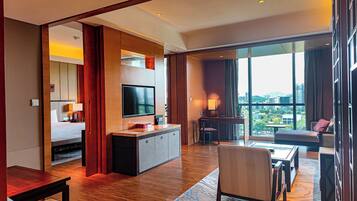 A hotel room with a large bed, a TV, a desk, and a view of the city.