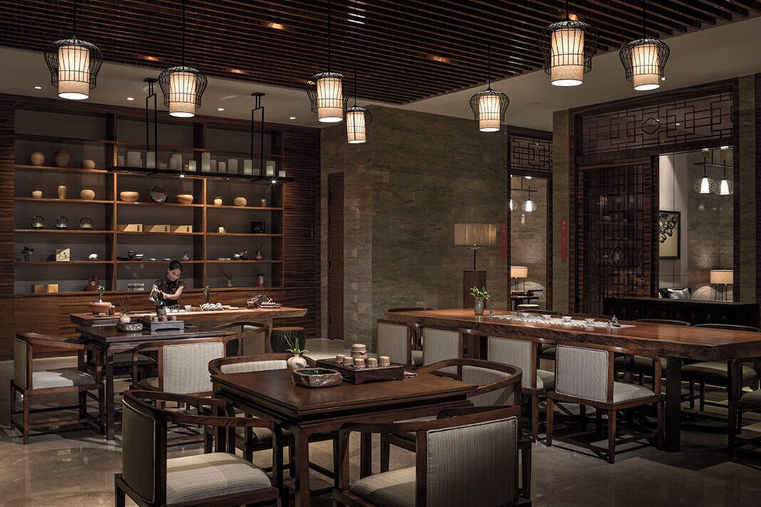 A traditional-style interior with wooden furniture, a central dining table, and hanging light fixtures.