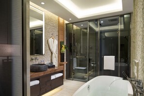 Ein modernes Badezimmer mit einer großzügigen Badewanne, einem runden Waschbecken und einer Duschkabine.