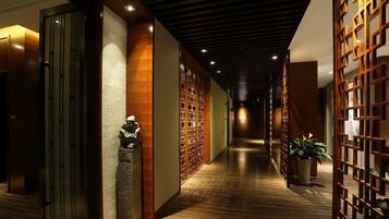 A corridor with wooden flooring, a statue, and a traditional wooden screen.