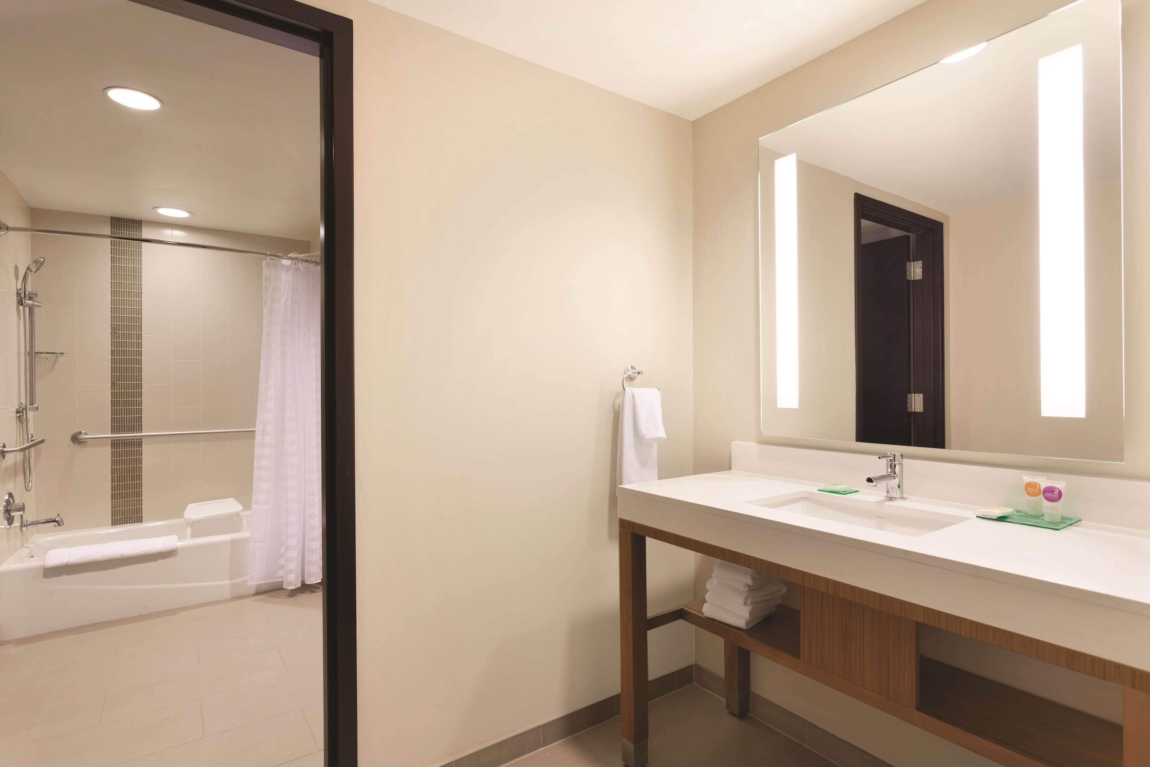 A modern bathroom with a bathtub, shower, and sink.