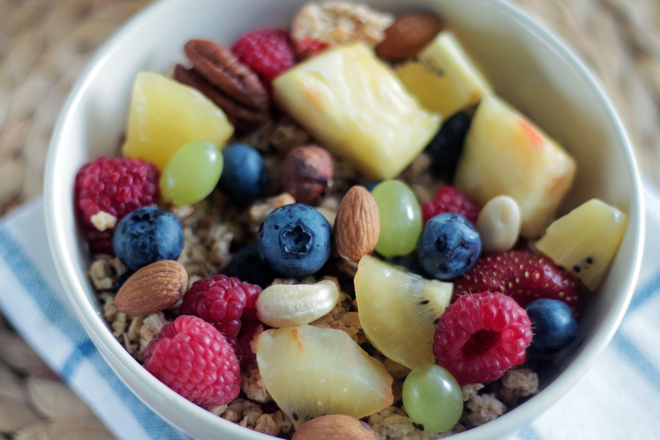 En skål med granola, nødder, tørret frugt og friske bær.