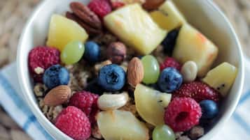 En skål med granola, nødder, tørret frugt og friske bær.