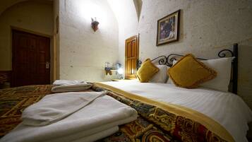 A room with a bed, a patterned bedspread, and a door.