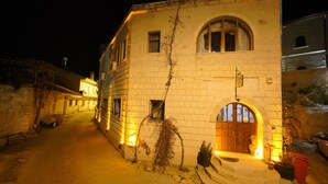 Un edificio histórico con fachada de piedra, puerta de madera y una ventana pequeña.