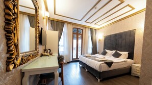 A hotel room with a large bed, a desk with a chair, a television, and a large mirror. - Diamond Royal Hotel (Istanbul)