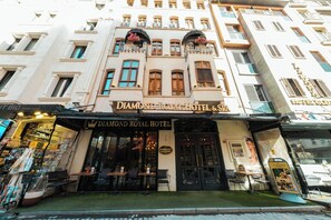 The exterior of the Diamond Royal Hotel & Spa with a traditional facade, large windows, and outdoor seating area. - Diamond Royal Hotel (Istanbul)
