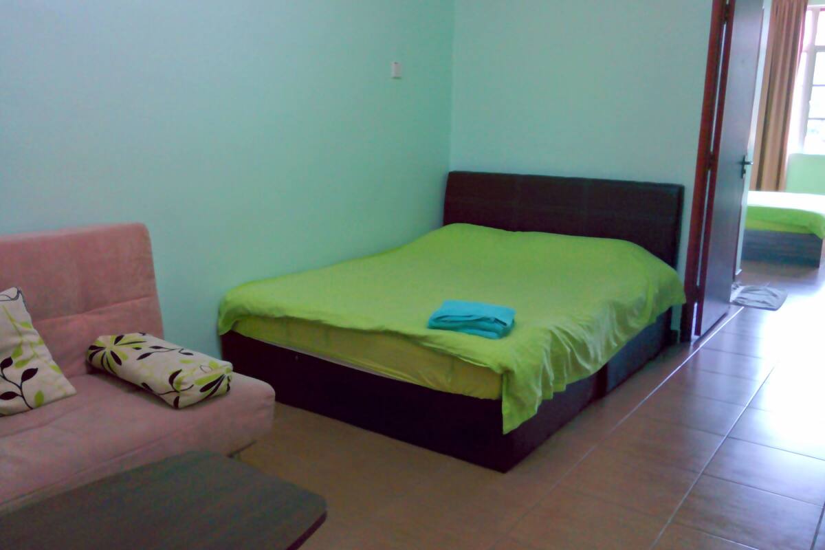 Una habitación con una cama, un sofá y una puerta que da a otra habitación.