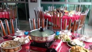 A table set with various dishes, utensils, and a hot pot. - Kea Valley Hotel Apartment (Brinchang)