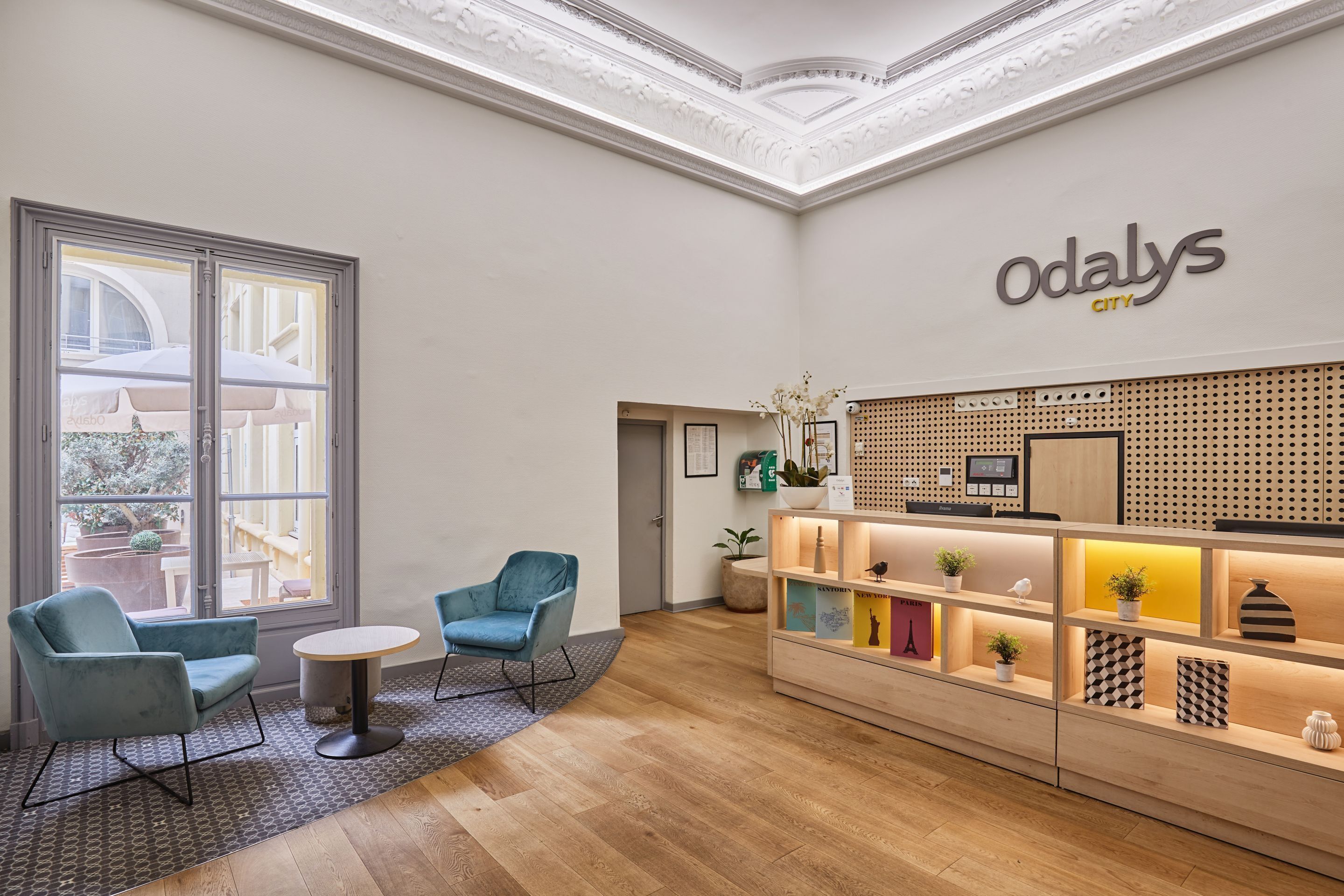 A reception area with a modern design, featuring a reception desk, seating area with chairs, and a large window providing natural light.