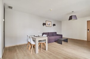 Una sala de estar moderna con una mesa de comedor, sillas, un sofá y una mesa de centro.
