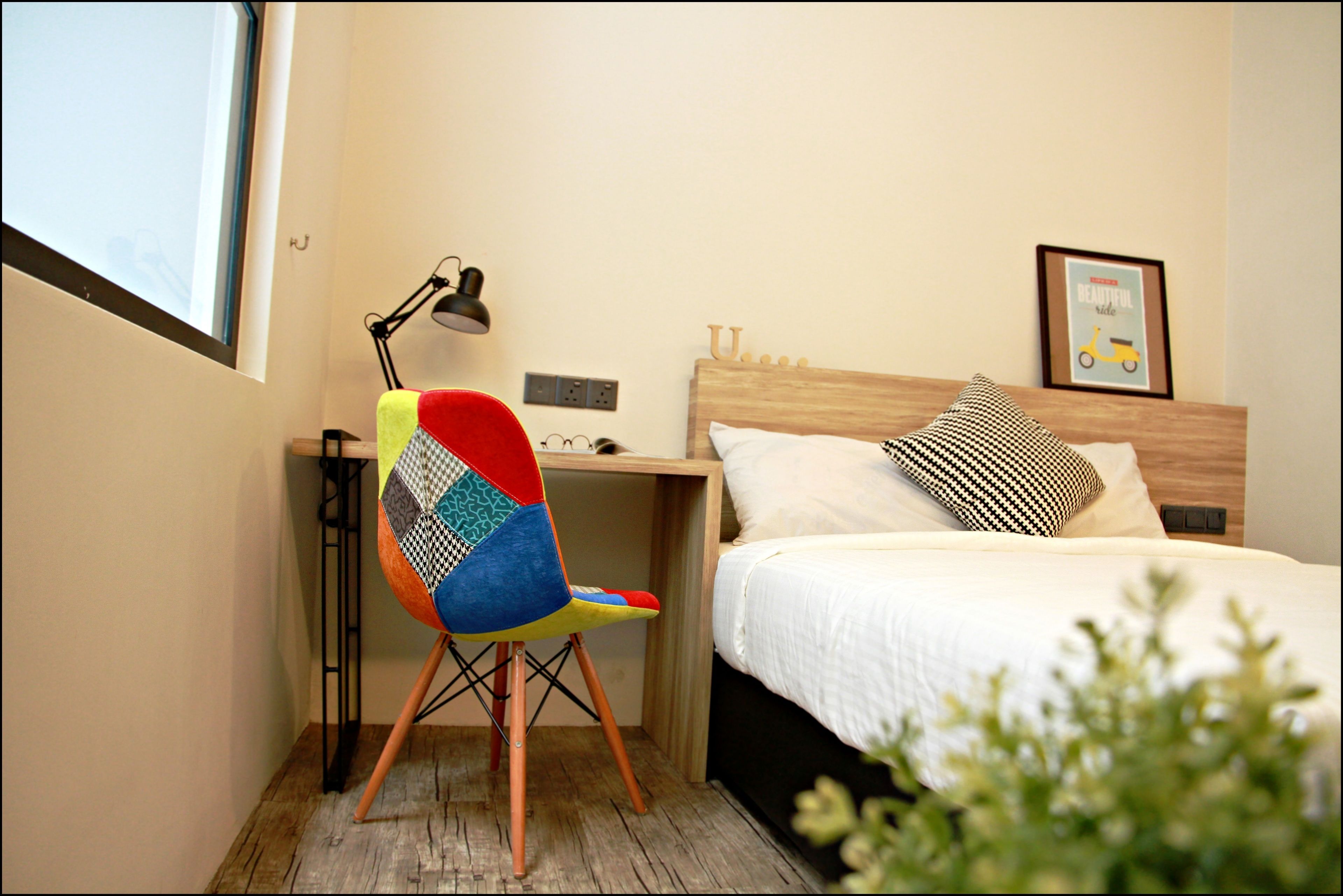 Une chambre à coucher comprenant un lit, un bureau, une chaise, une lampe et une étagère fixée au mur.