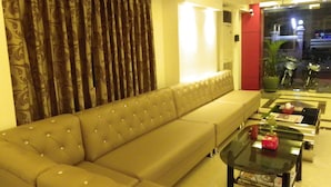 Una sala de estar con un sofá beige, una mesa de centro de vidrio y vistas a la calle.