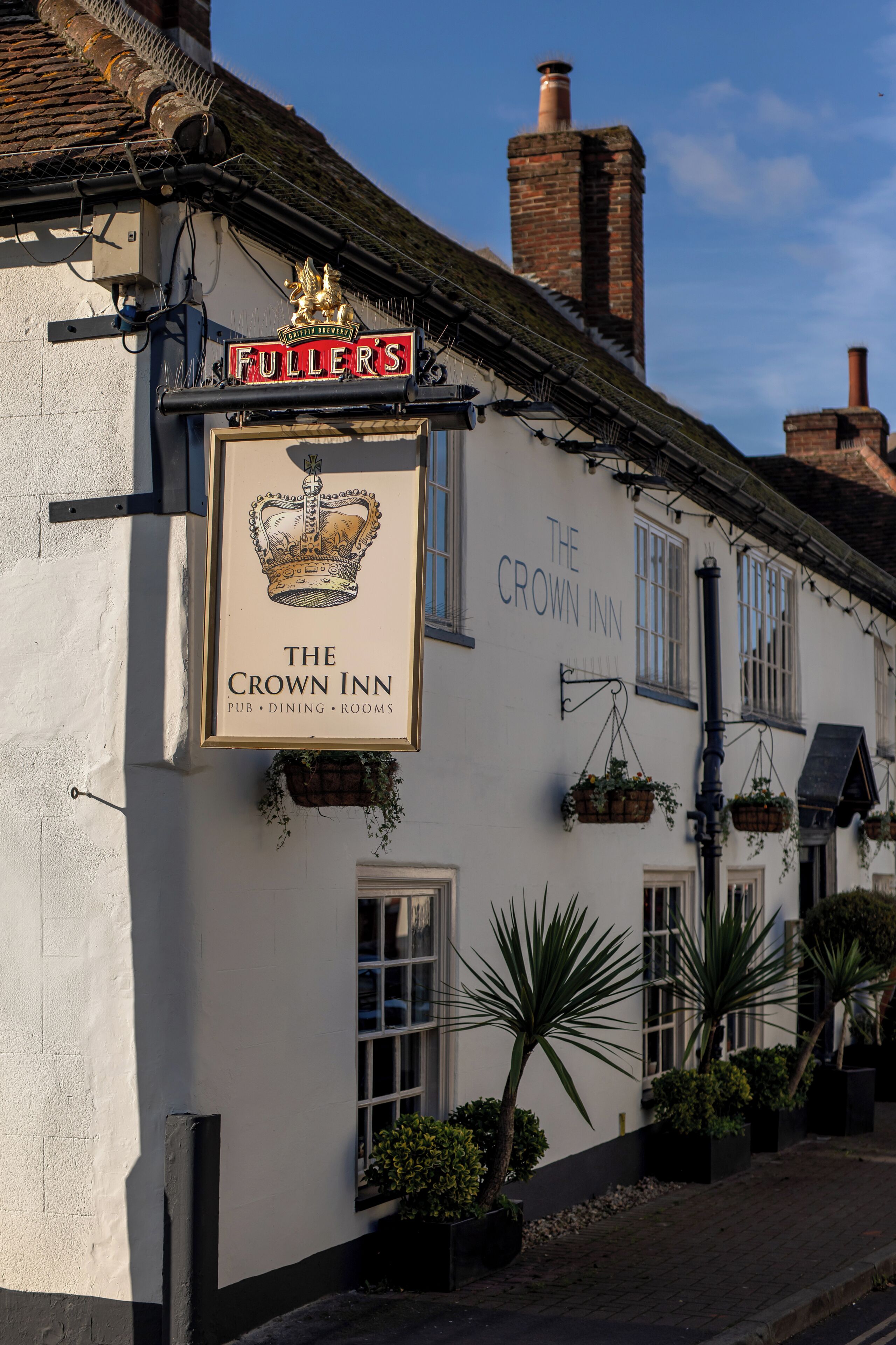 A traditional pub named "The Crown Inn" with a sign featuring a crown emblem.