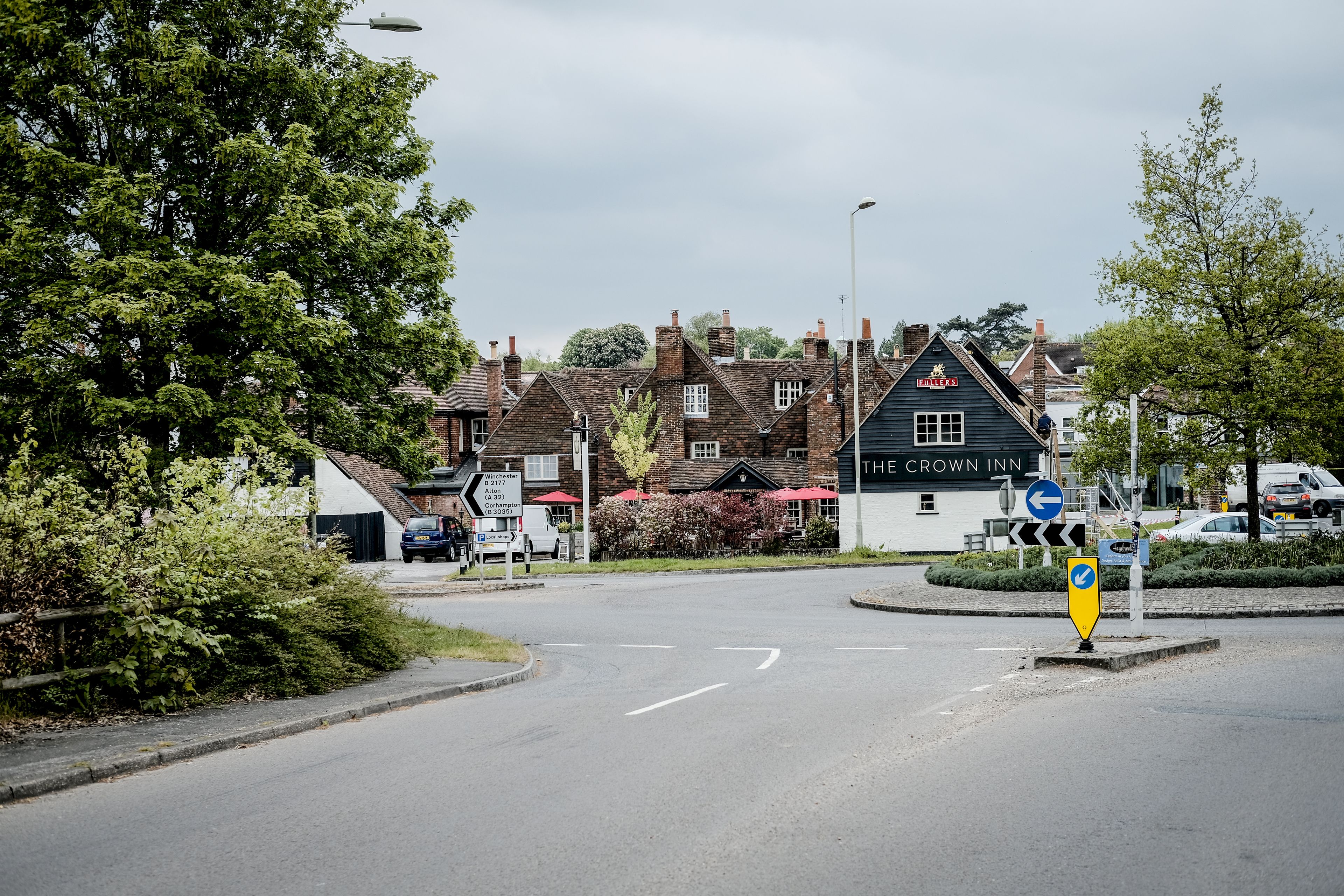 A road leading to a building with a sign reading "The Crown Inn."