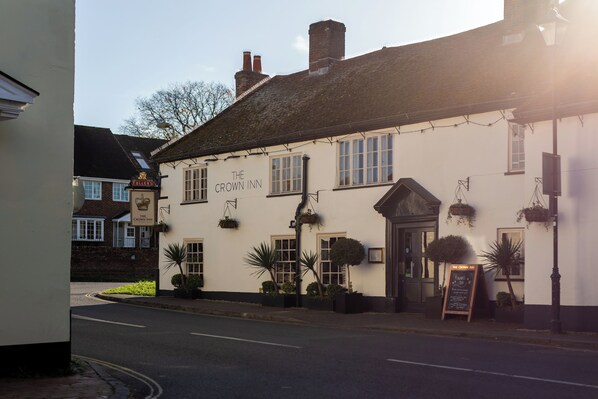 A white building with a sign reading "The Crown Inn."