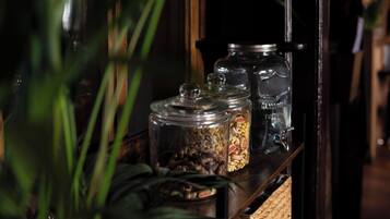 A shelf with glass jars containing various items, possibly spices or condiments, and a woven basket.