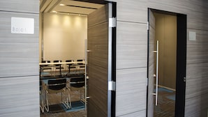 A hotel room with a minibar, a desk with chairs, and a bathroom with a toilet and sink. - Hotel Casa Inn Galerias (Celaya)