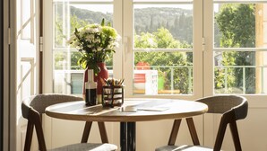 Une table ronde avec quatre chaises, un vase rempli de fleurs et un porte-stylos contenant des crayons.
