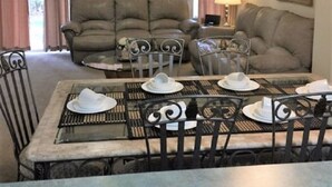 Een eetgedeelte met een tafel voor vier personen, twee banken en een lamp.