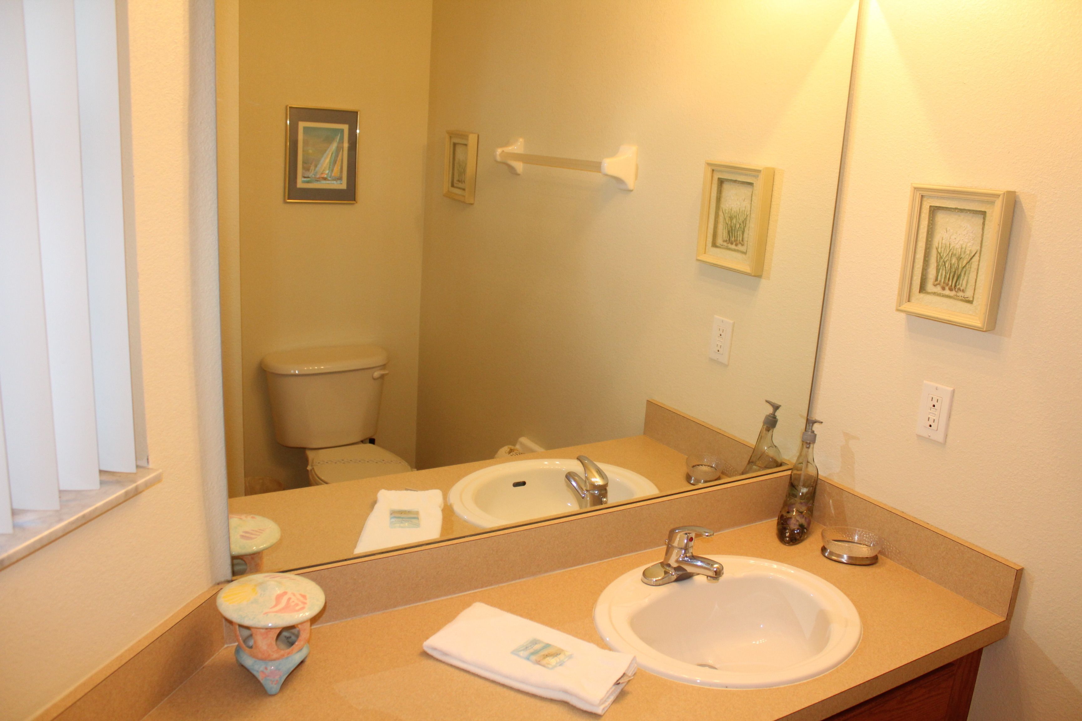 A bathroom with a sink, mirror, and toilet.