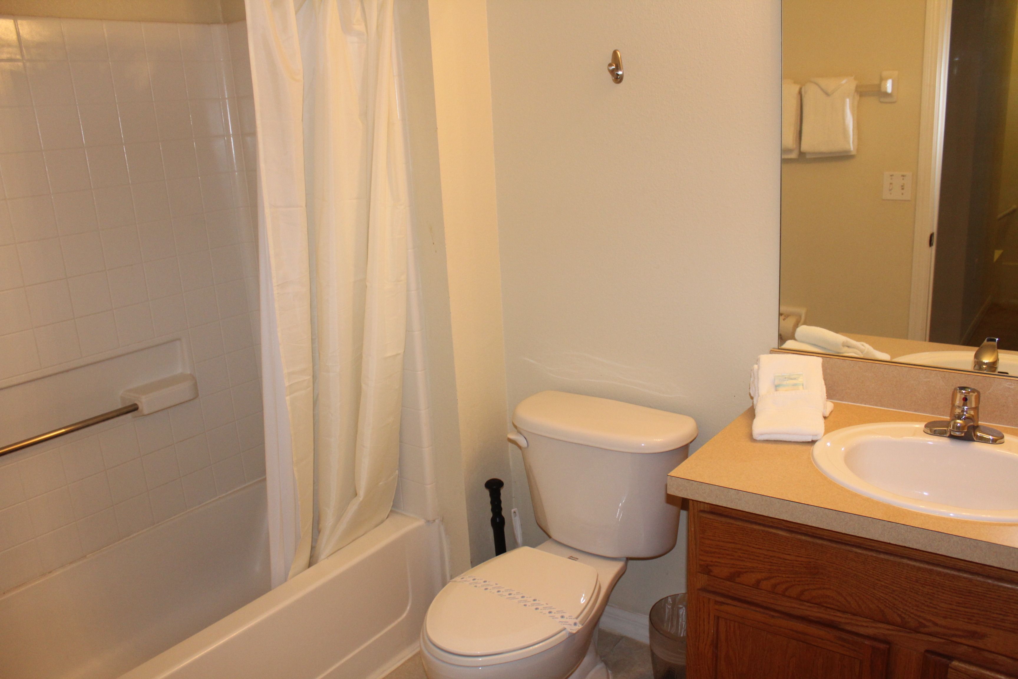 A bathroom with a toilet, sink, and bathtub.