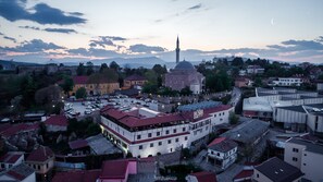 A hotel with a red roof, a large building with a dome, and a mosque with a minaret in the background. - Bushi Resort & Spa (Skopje)