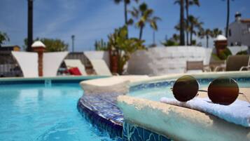 Alberca al aire libre, sombrillas en la alberca y camastros