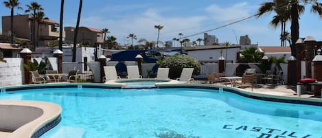 Alberca al aire libre, sombrillas en la alberca y camastros