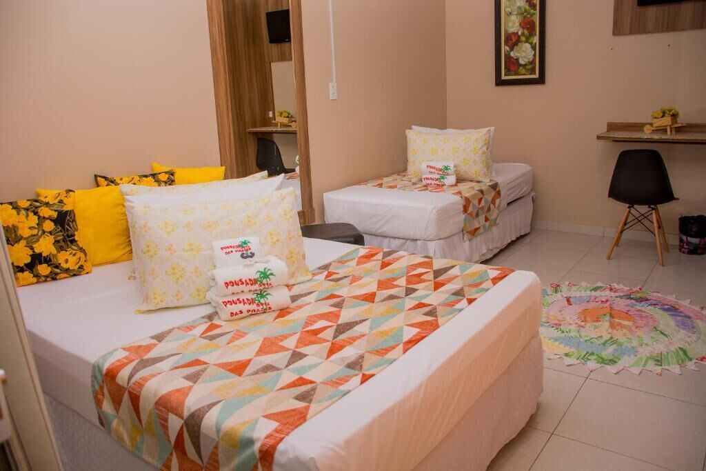 Una habitación de hotel con dos camas, un escritorio y una silla.