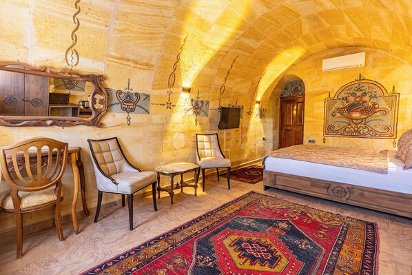 Une pièce comprenant un lit, des chaises, un miroir et un tapis à motifs.