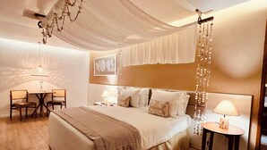 A bedroom with a large bed, a desk, and a chair.