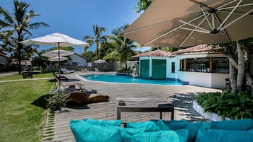 Una piscina al aire libre, sombrillas, sillones reclinables de piscina