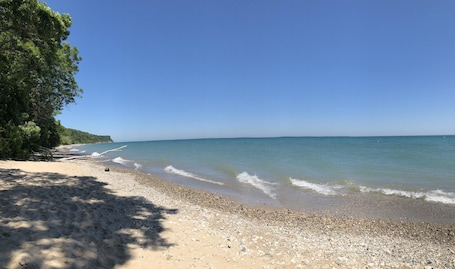 Una playa cerca, sillas reclinables de playa, sombrillas