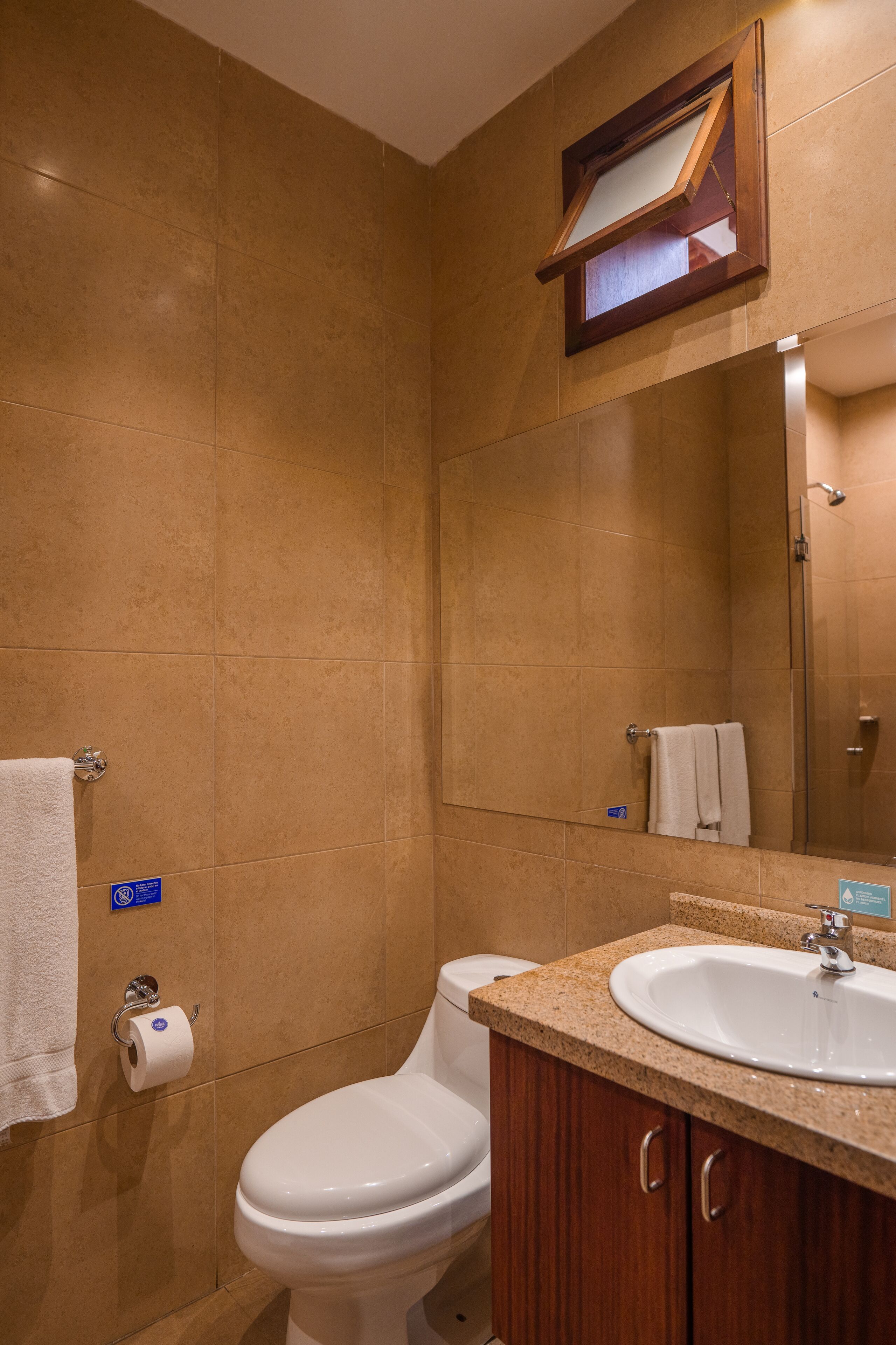 A bathroom with a toilet, sink, and mirror.