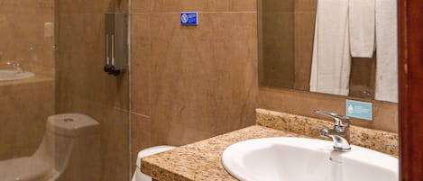 A bathroom with a toilet, sink, and shower.