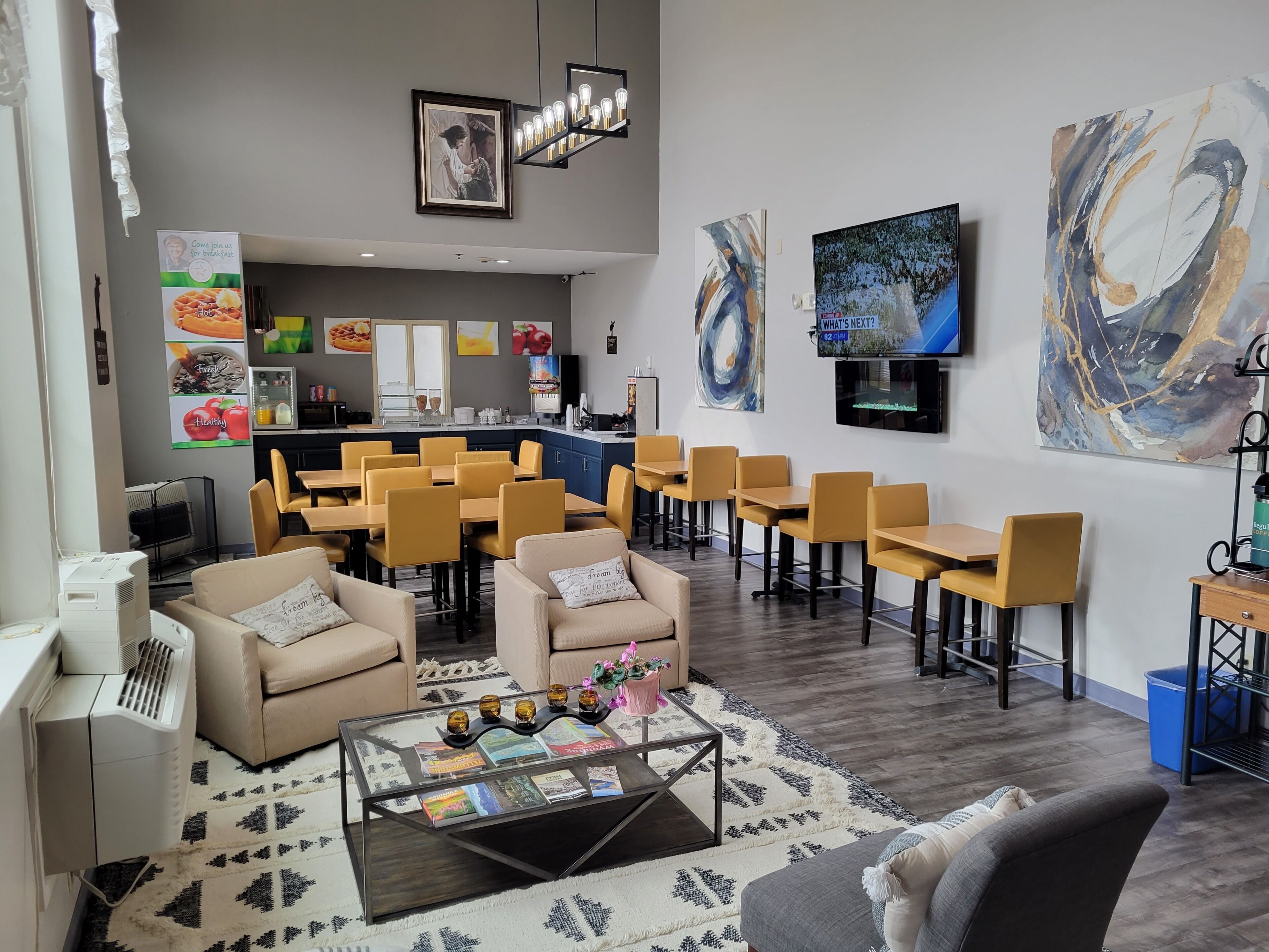 A modern hotel lobby with a bar area, seating arrangements, and artwork on the walls.