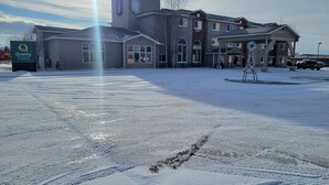 A hotel with a large parking lot, a covered area, and a sign indicating it is a Quality Inn & Suites by CHICAGO HOTEL. - Quality Inn & Suites Pinedale (Pinedale)