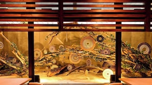 A restaurant interior with wooden slats overhead, a long table, and chairs. - Lit Hotel NAKIJIN (Nakijin)