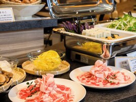 Un bufé con diferentes opciones de comida, incluyendo carne cortada, verduras y otros platos.