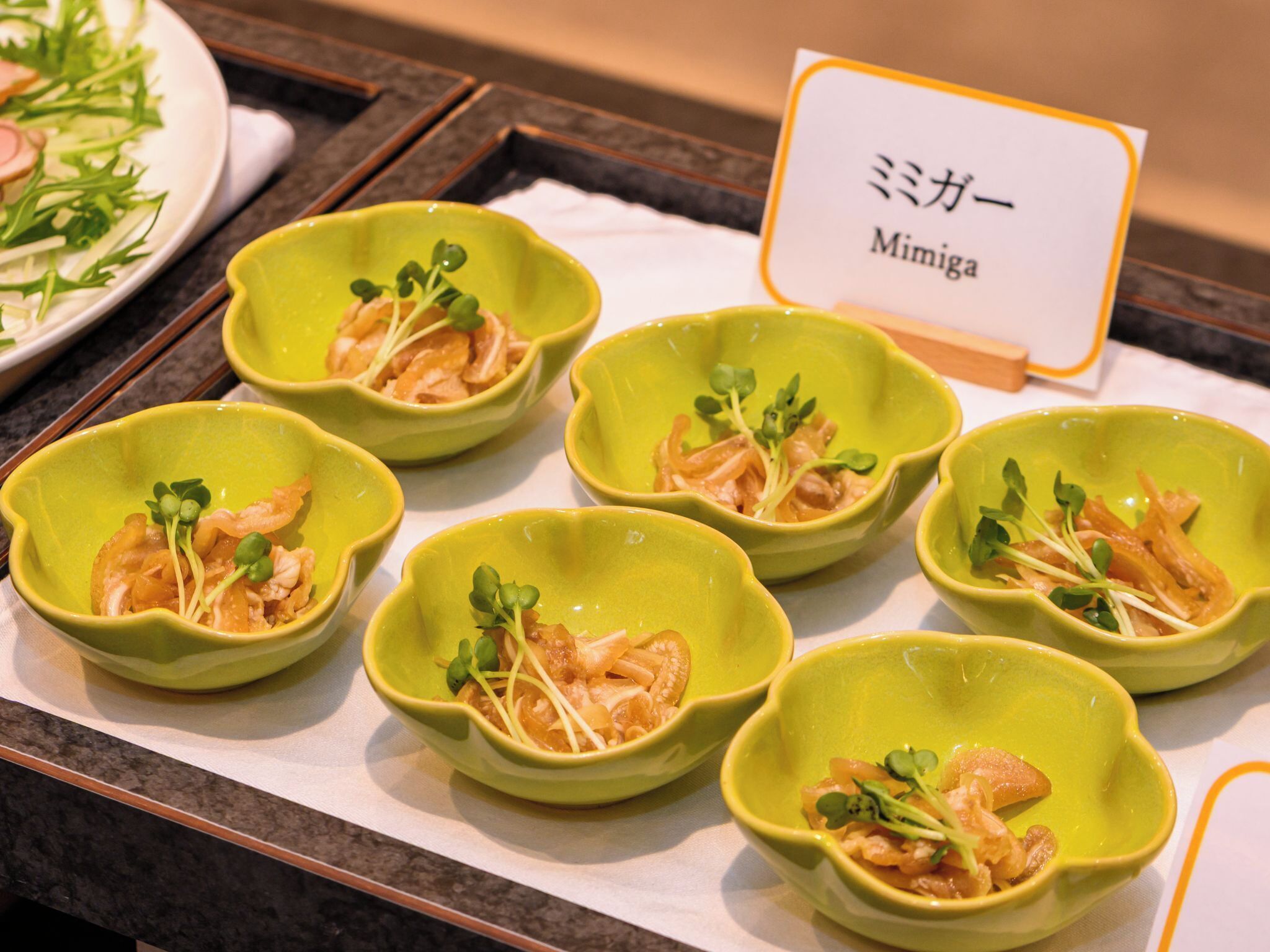 A table with six green bowls containing food, each with a label reading 'Mimiga.'